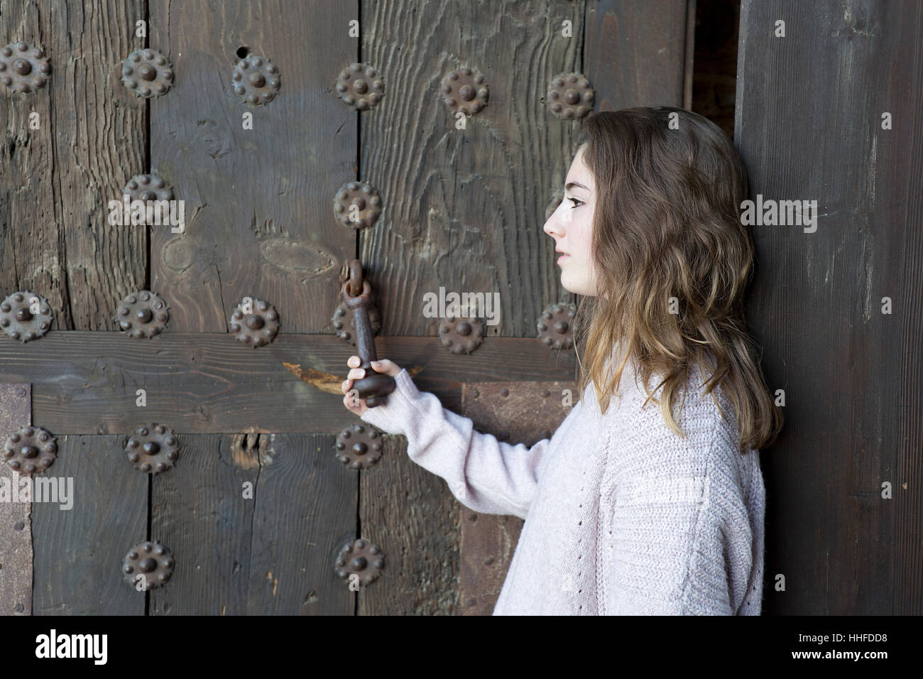 Mädchen im Profil auf einem Hintergrund von einer alten Tür. Horizontalen Schuss mit natürlichem Licht. Stockfoto