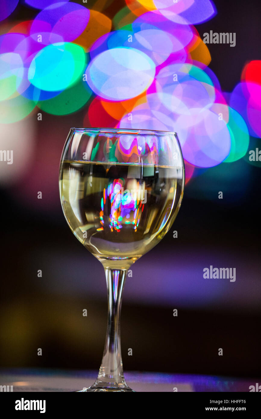 Ein Glas Pinot Grigio weißen Wein mit funkelnden Lichter im Hintergrund Stockfoto
