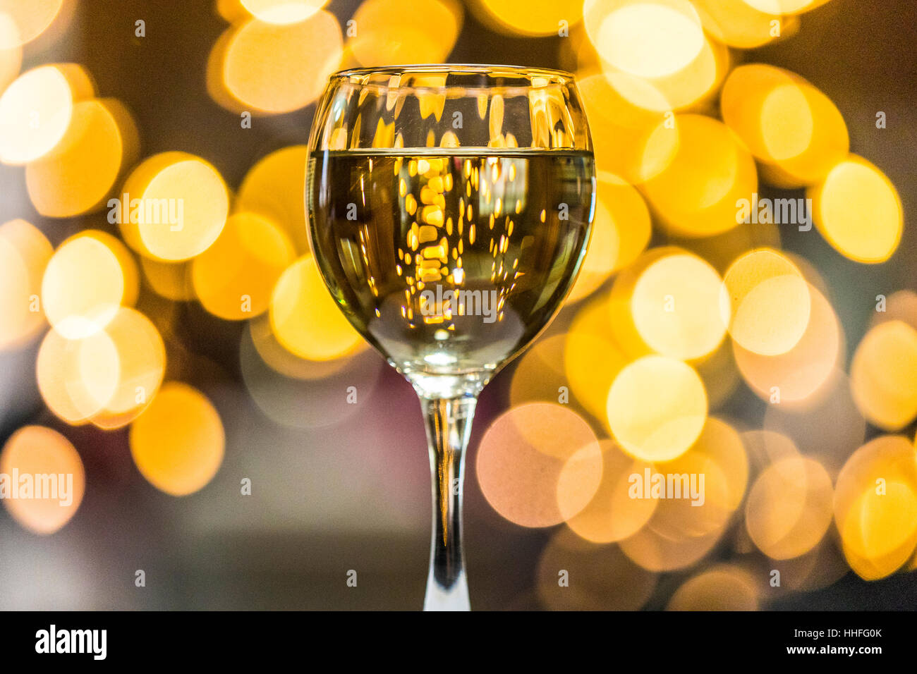 Ein Glas Pinot Grigio weißen Wein mit funkelnden Lichter im Hintergrund Stockfoto