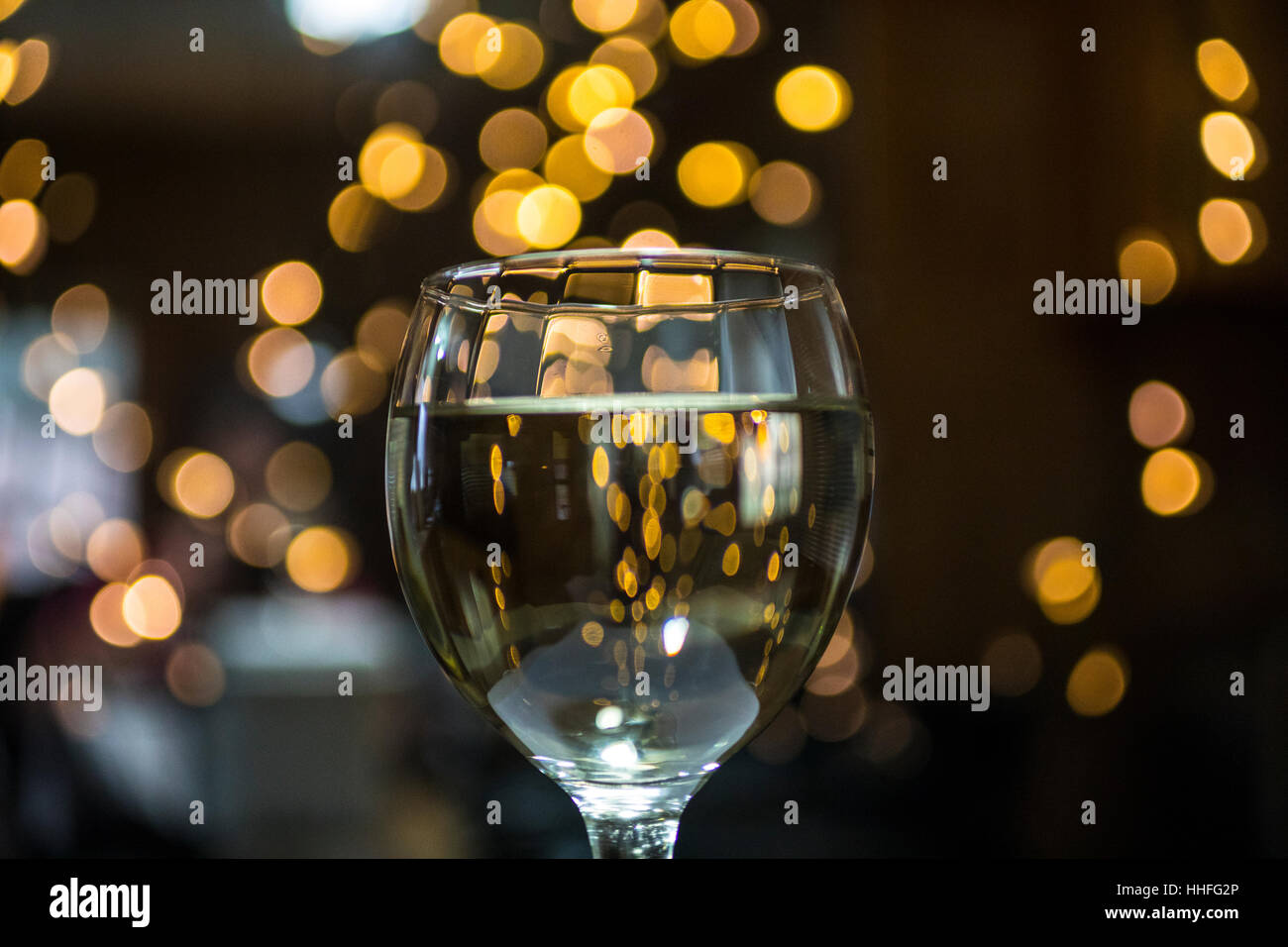 Ein Glas Pinot Grigio weißen Wein mit funkelnden Lichter im Hintergrund Stockfoto