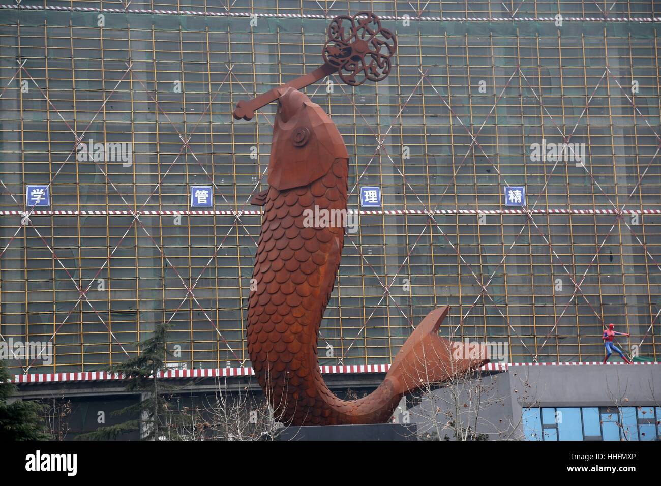 Zhengzhou, China. 18. Januar 2017. (NUR ZUR REDAKTIONELLEN VERWENDUNG. CHINA aus) eine riesige Skulptur der Karpfen zeigt auf der Straße in Zhengzhou, Hauptstadt der Provinz Zentral-China Henan. Die Karpfen 22 Meter hohen Skulptur, entworfen von dem Künstler Huang Guorui, kostet mehr als 800.000 Yuan (US$ 117.027). Menschen sehen ein riesiges s-förmige Ornament im Mund die Karpfen-Skulptur aus Gusseisen, als Symbol für Glück. Bildnachweis: SIPA Asien/ZUMA Draht/Alamy Live-Nachrichten Stockfoto