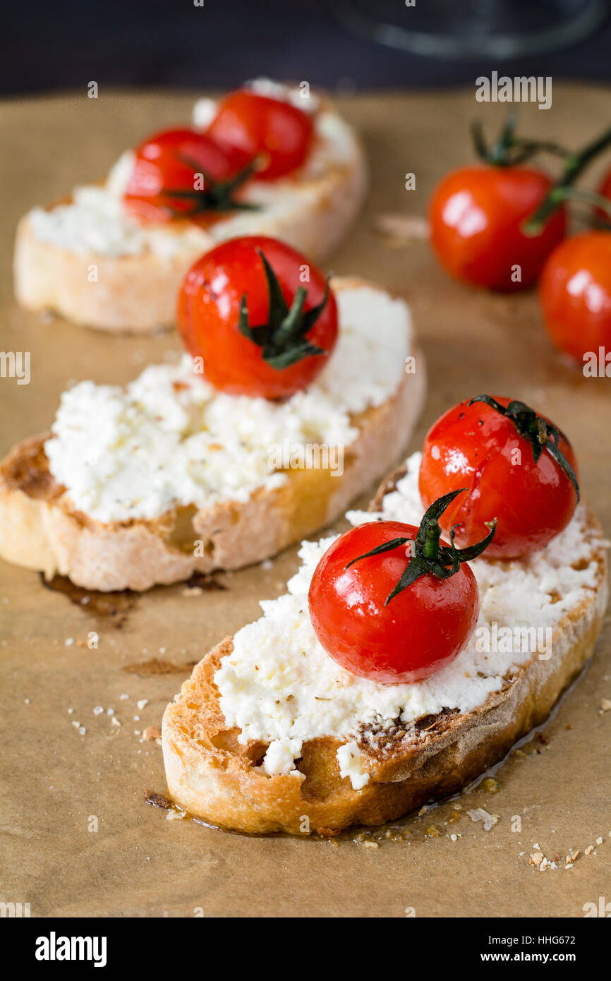Bruschetta mit gerösteten Tomaten und frischem Ricotta-Käse, garniert mit Olivenöl extra vergine. Italienische Küche Vorspeise. Stockfoto