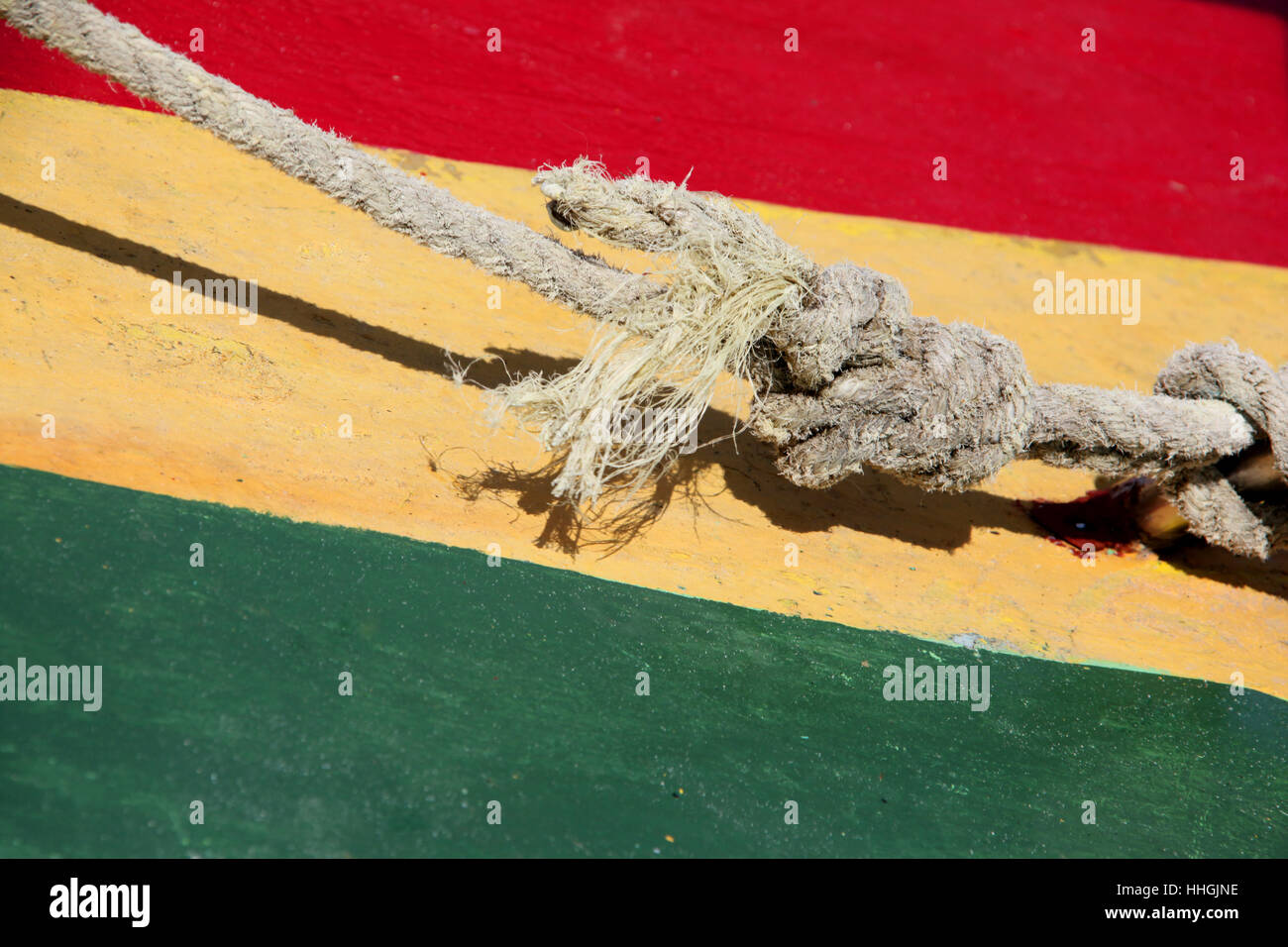 Typische Rastafari Karibik Farben von rot, grün & gelb, gemalt auf Holz, mit einem nautischen Knoten vor, St. George, Grenada. Stockfoto