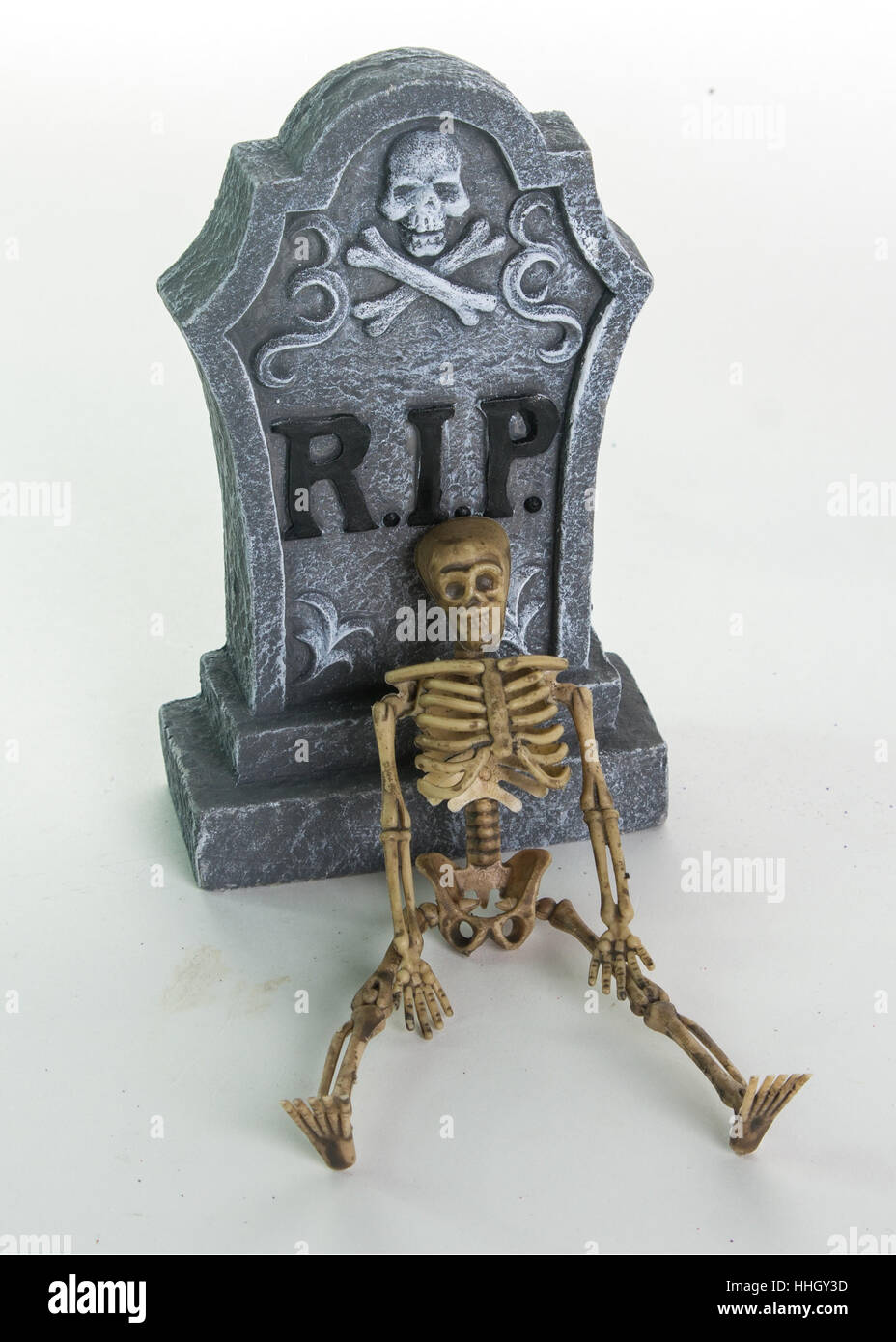 Ruhe in Frieden Grabstein mit Skelleton und gestapelten Schädeln. Isoliert auf weißem Hintergrund Stockfoto