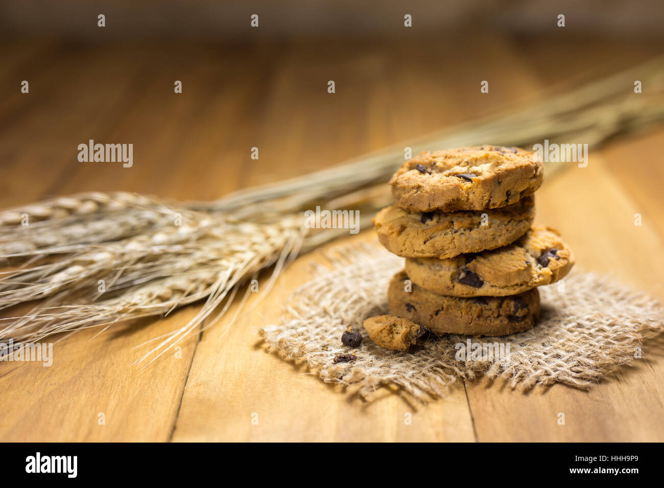 Schokoladen-Plätzchen auf meschotschek Tuch auf Holz. Chocolate Chip Cookies und Reis Malz erschossen auf einem braunen Tuch. Stockfoto