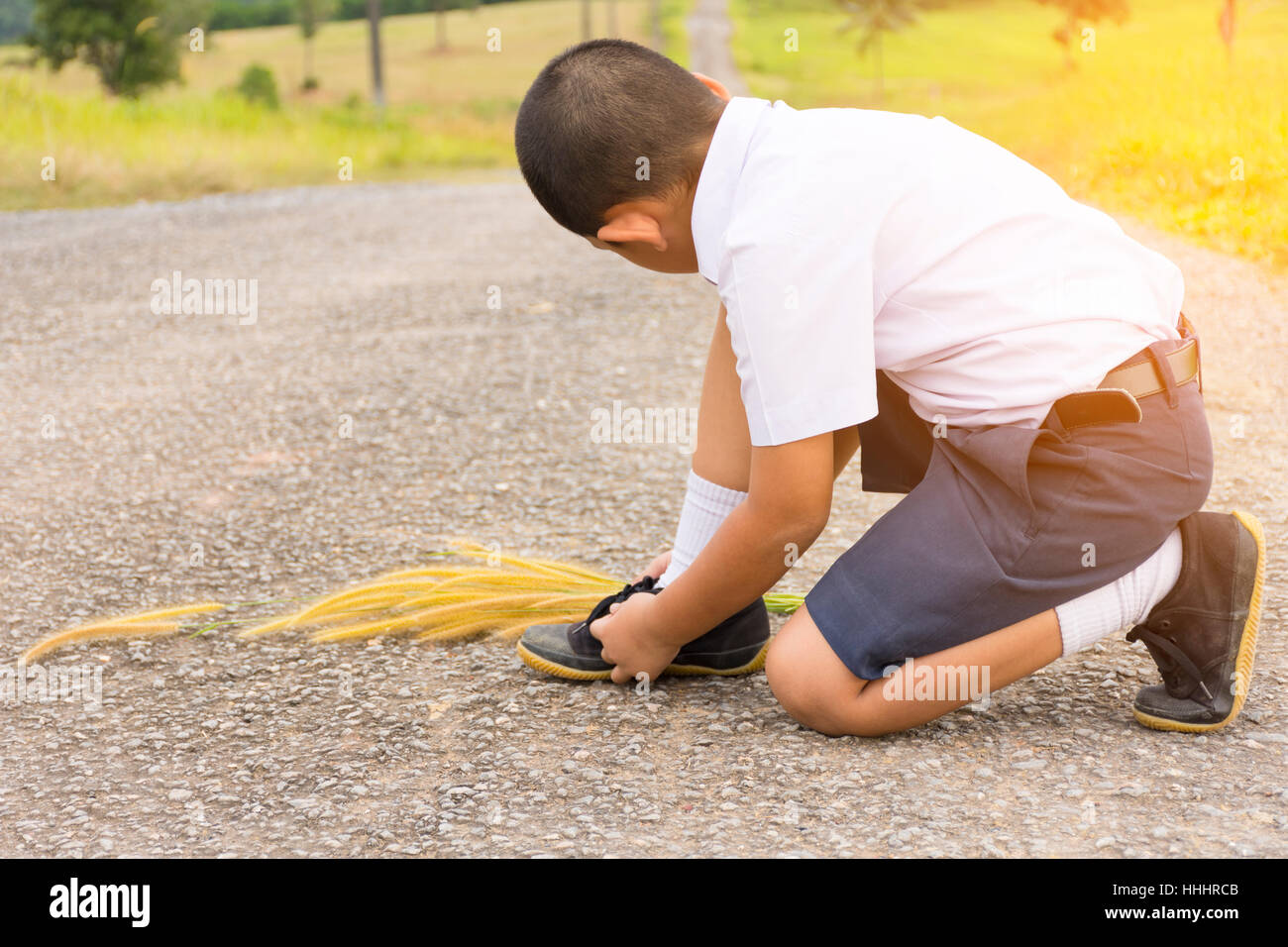 Kinder Schüler binden Schuhe bei roadside.0001 Stockfoto