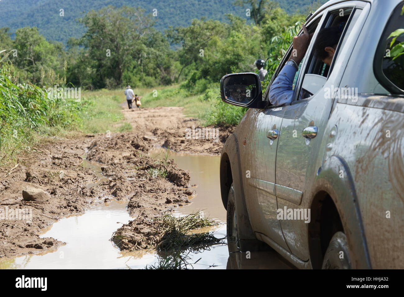 Abholung / Auto stecken im Schlamm in abgelegenen Kambodscha (Samlout, Battambang) mit 2 Personen in der Ferne Stockfoto