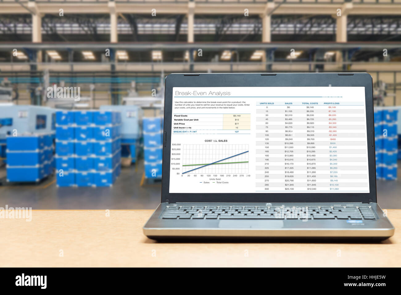 Laptop mit Auswertungsbildschirm auf Tisch mit blur Lager Fracht im Werk. Konzept der smart Factory. Stockfoto