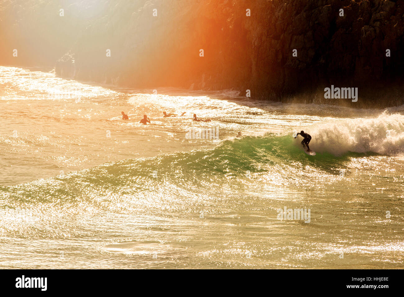 Surfen - Surfer auf der Welle bei Sonnenuntergang Stockfoto