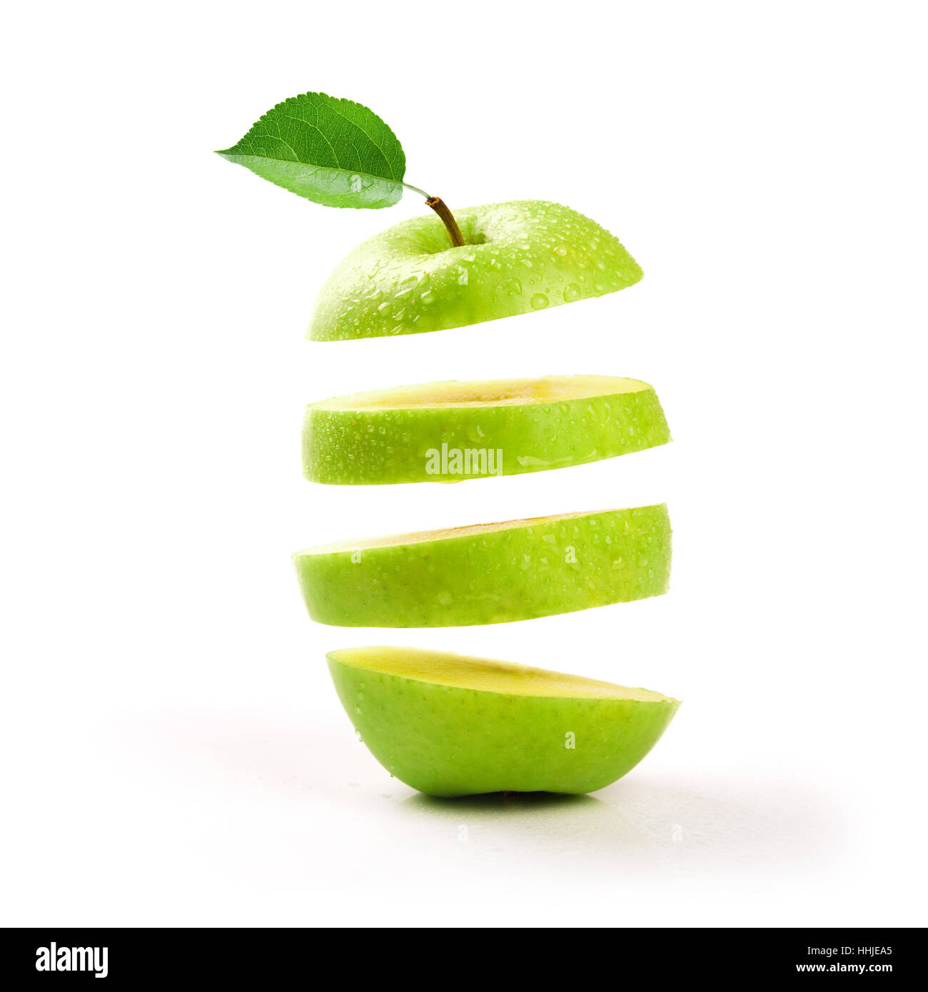 in Scheiben geschnitten, grüner Apfel schwebend auf weißem Hintergrund Stockfoto