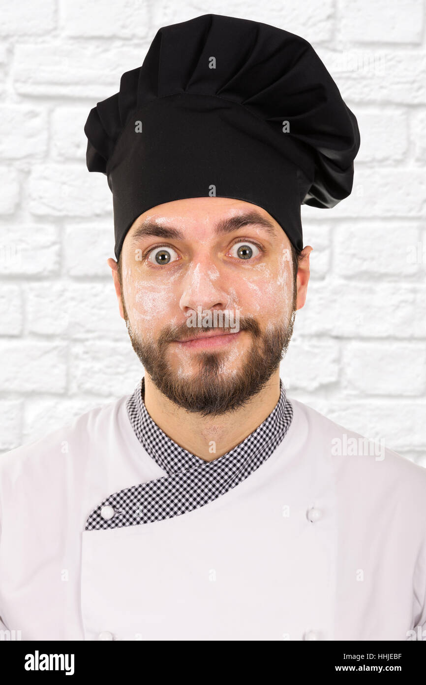 lustige Porträt des Küchenchefs mit Mehl auf Gesicht Stockfoto