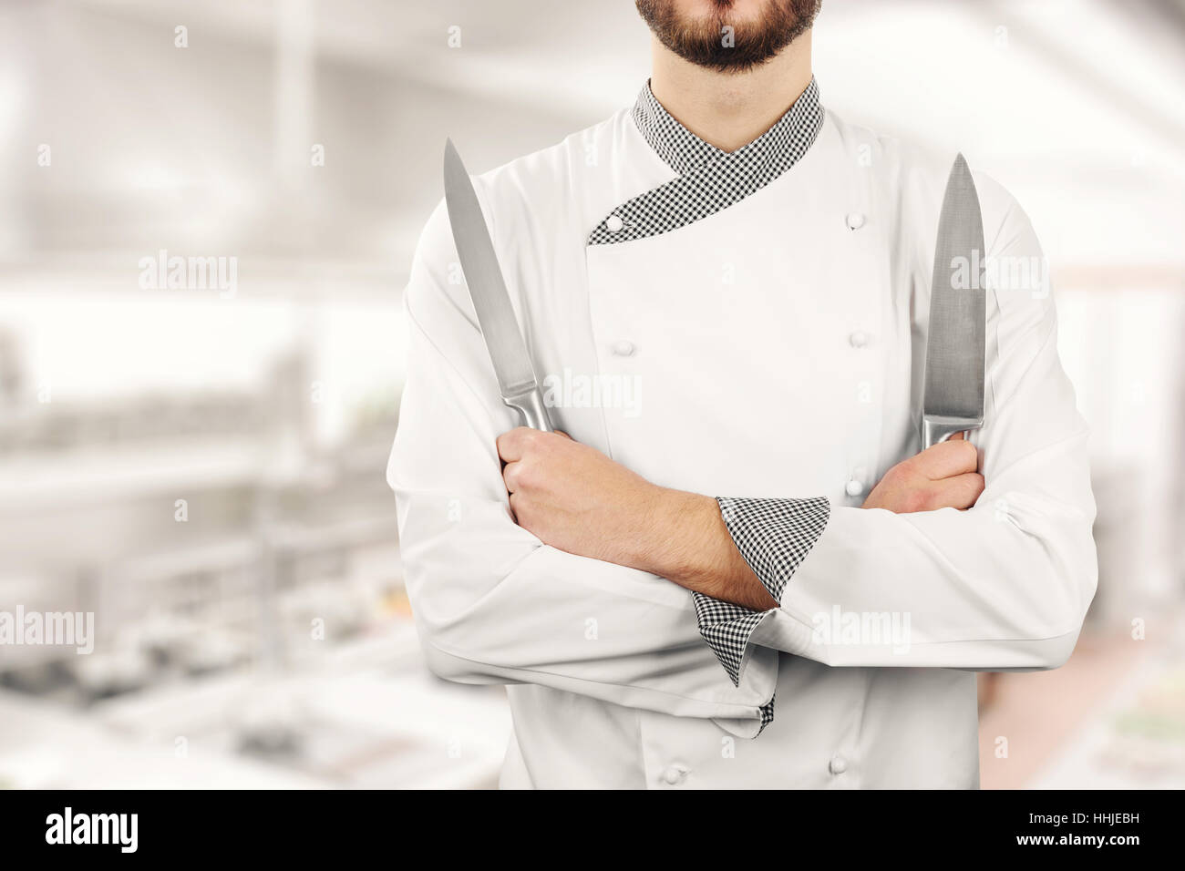 Koch in der Restaurantküche mit Messern in Händen Stand Stockfoto