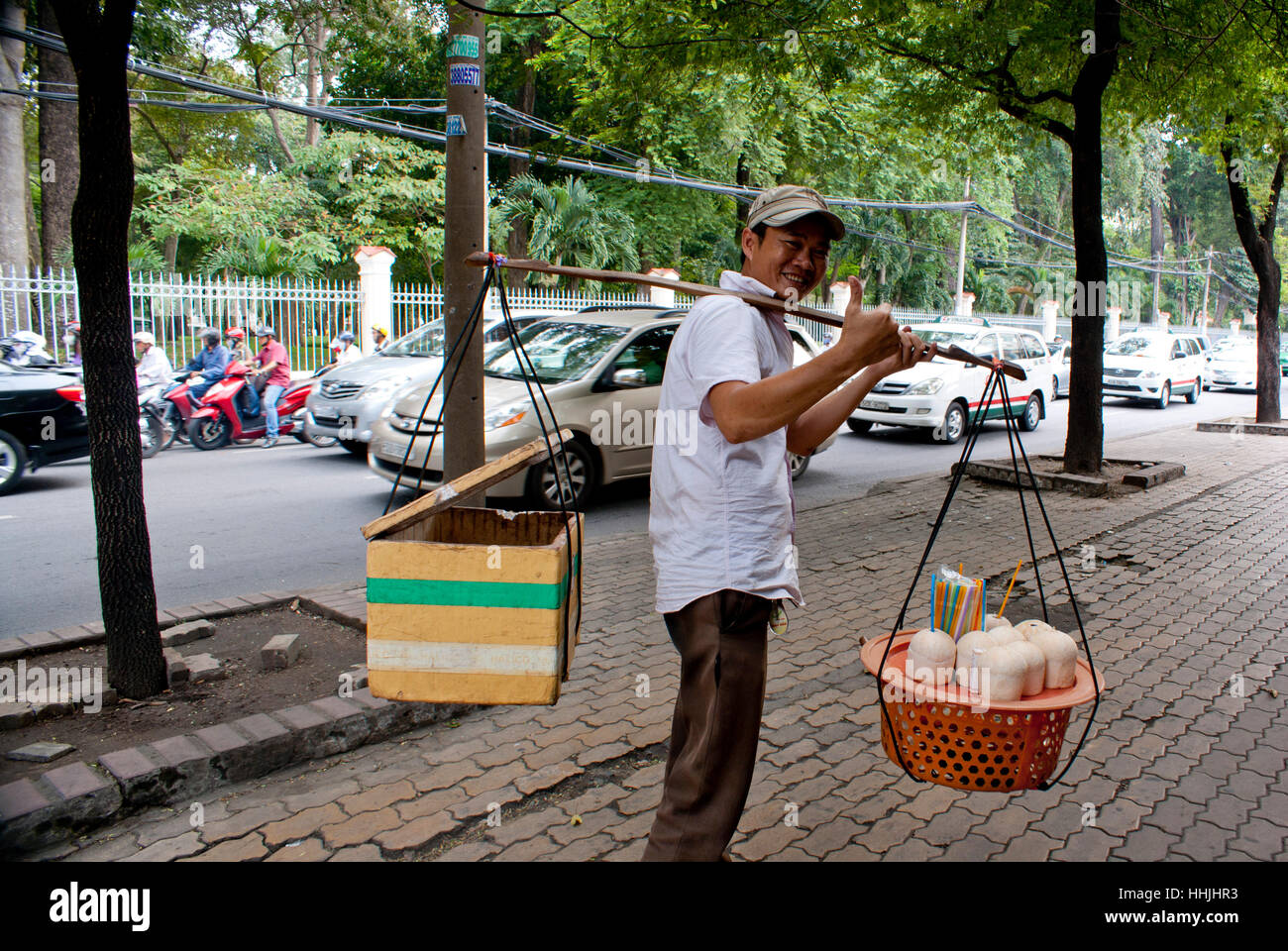Kokos-Verkäufer zu Fuß auf einer Straße in Saigon, Vietnam. Stockfoto