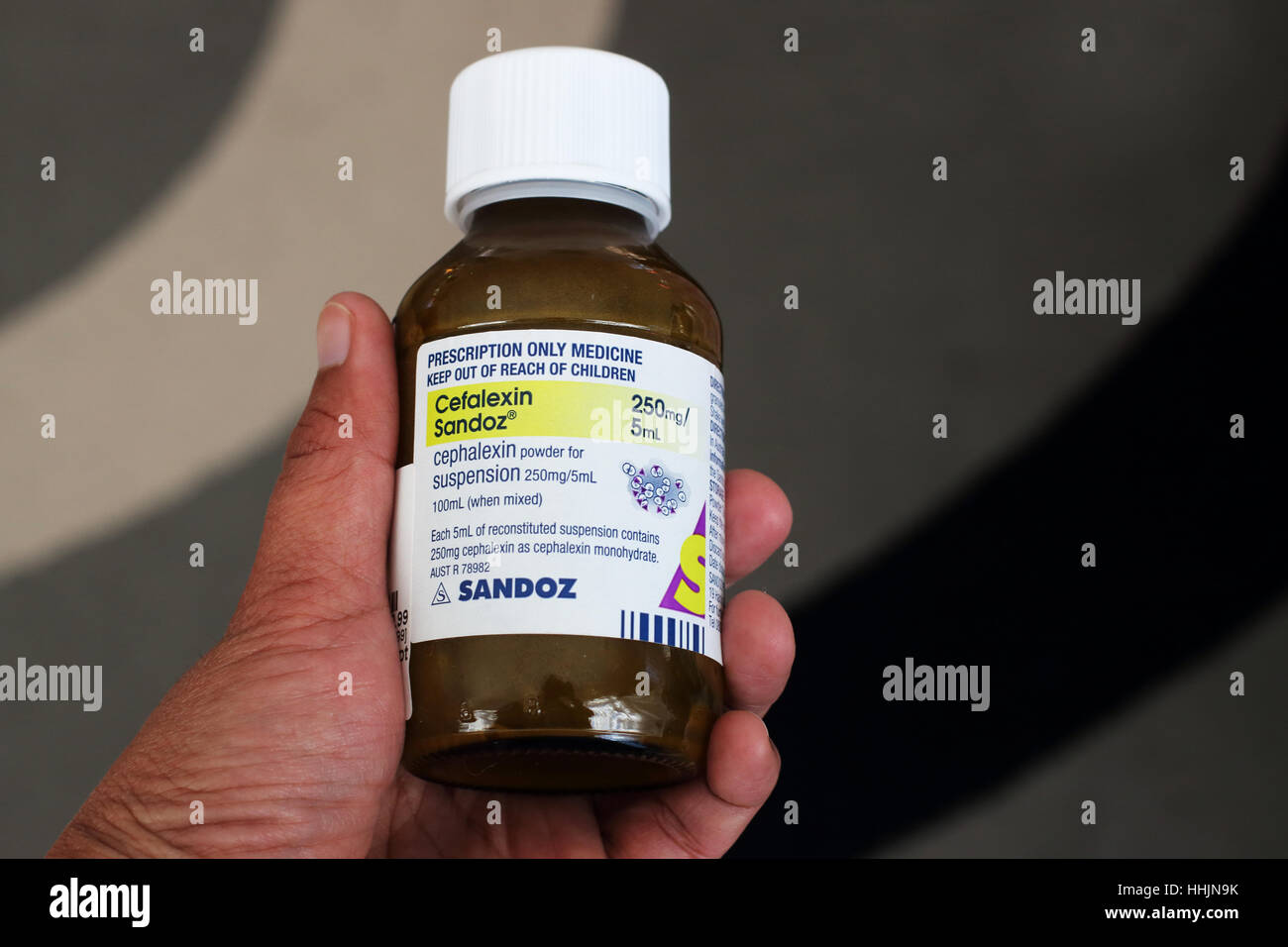 Hand hält Cefalexin Sandoz Antibiotikum Stockfoto