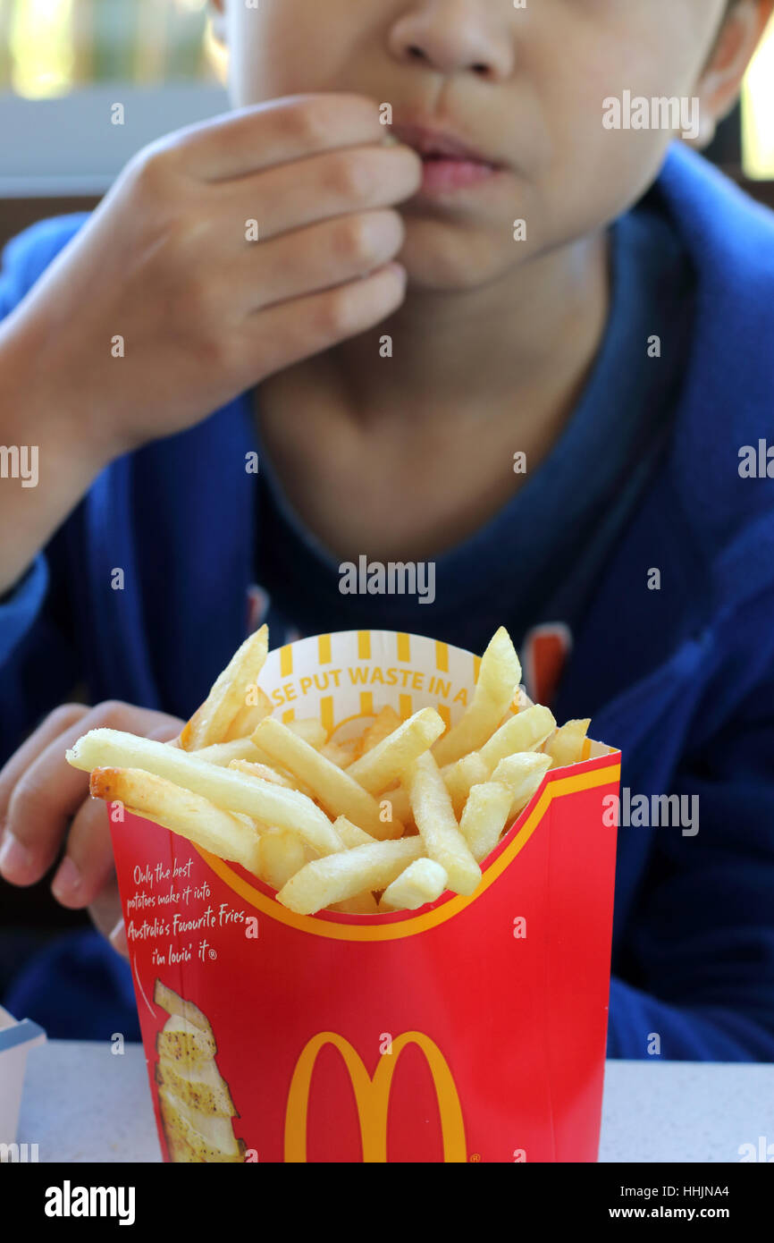 Nahaufnahme eines Kindes Essen McDonalds Pommes frites bei McDonald's Melbourne Victoria Australien Stockfoto