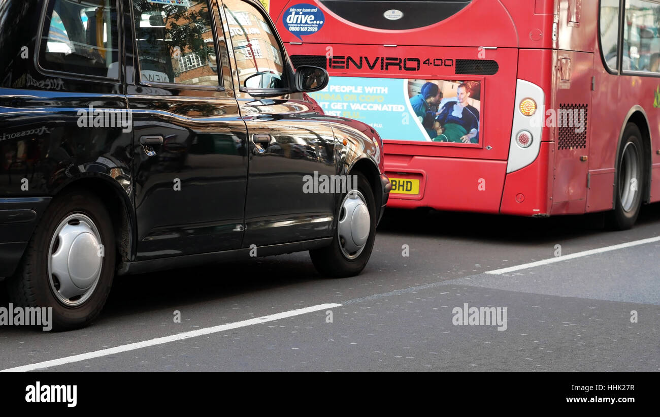 Schwarzes Taxi und Doppeldecker-Bus auf der Straße Stockfoto