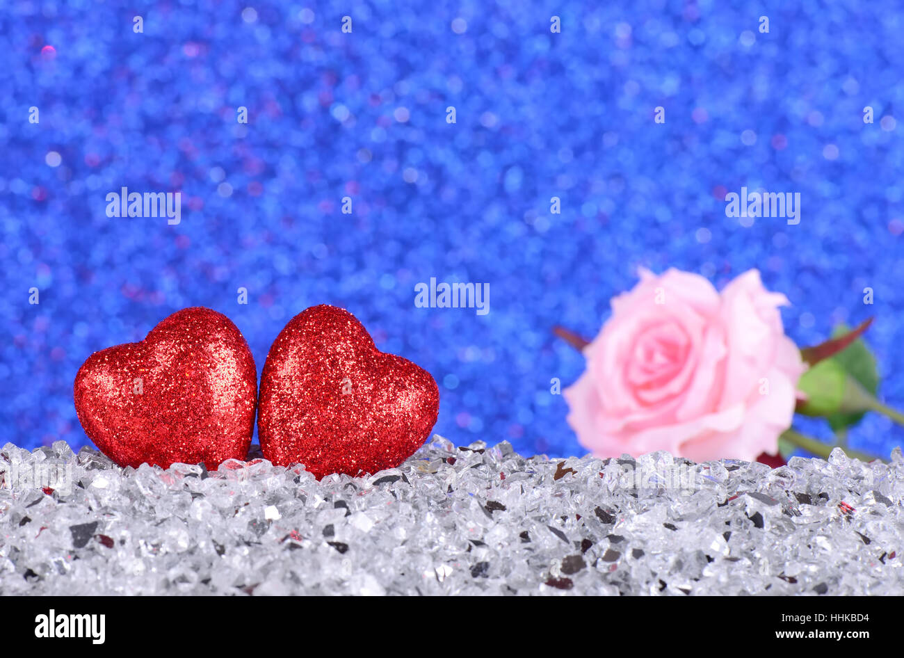Rotes Herzformen und rosa rose Blume auf abstrakte Licht blau Glitzer Hintergrund in Liebe Konzept für Valentinstag und romantische Momente Stockfoto