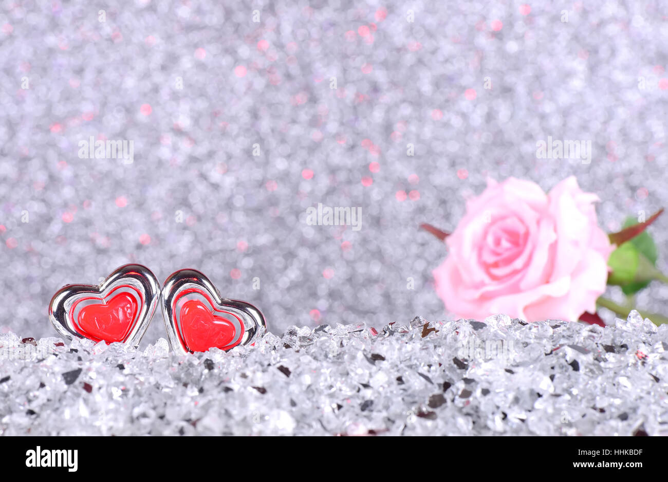 Das rote Herz formen und rosa Rose Blume auf abstrakte Licht Silber Glitzer Hintergrund in Liebe Konzept für Valentines Tag und romantischen Moment Stockfoto