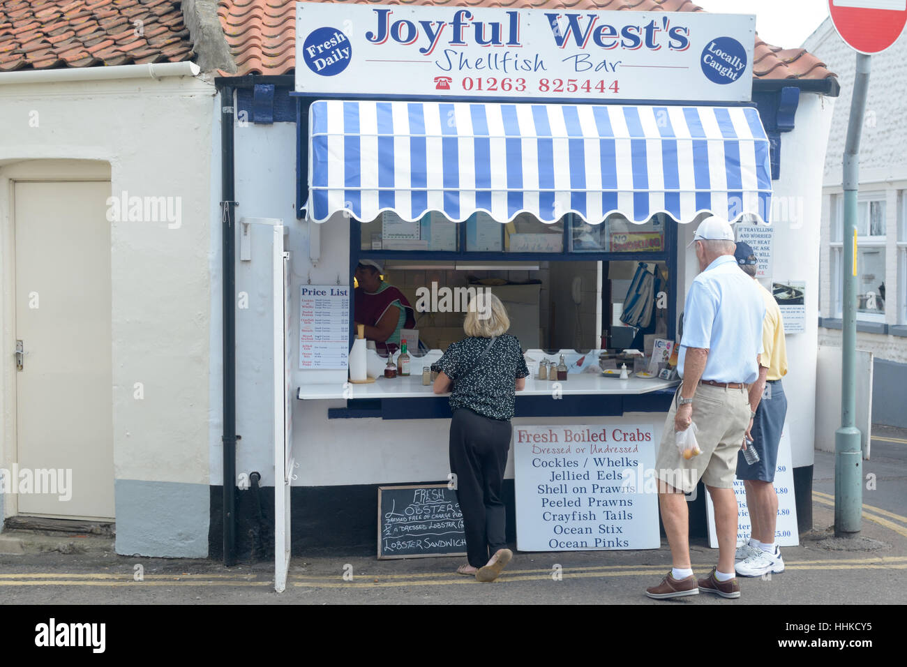 Kunden, die Schlange für die Lebensmittel vor freudiger West Schalentiere Bar in Sheringham, Norfolk, England Stockfoto