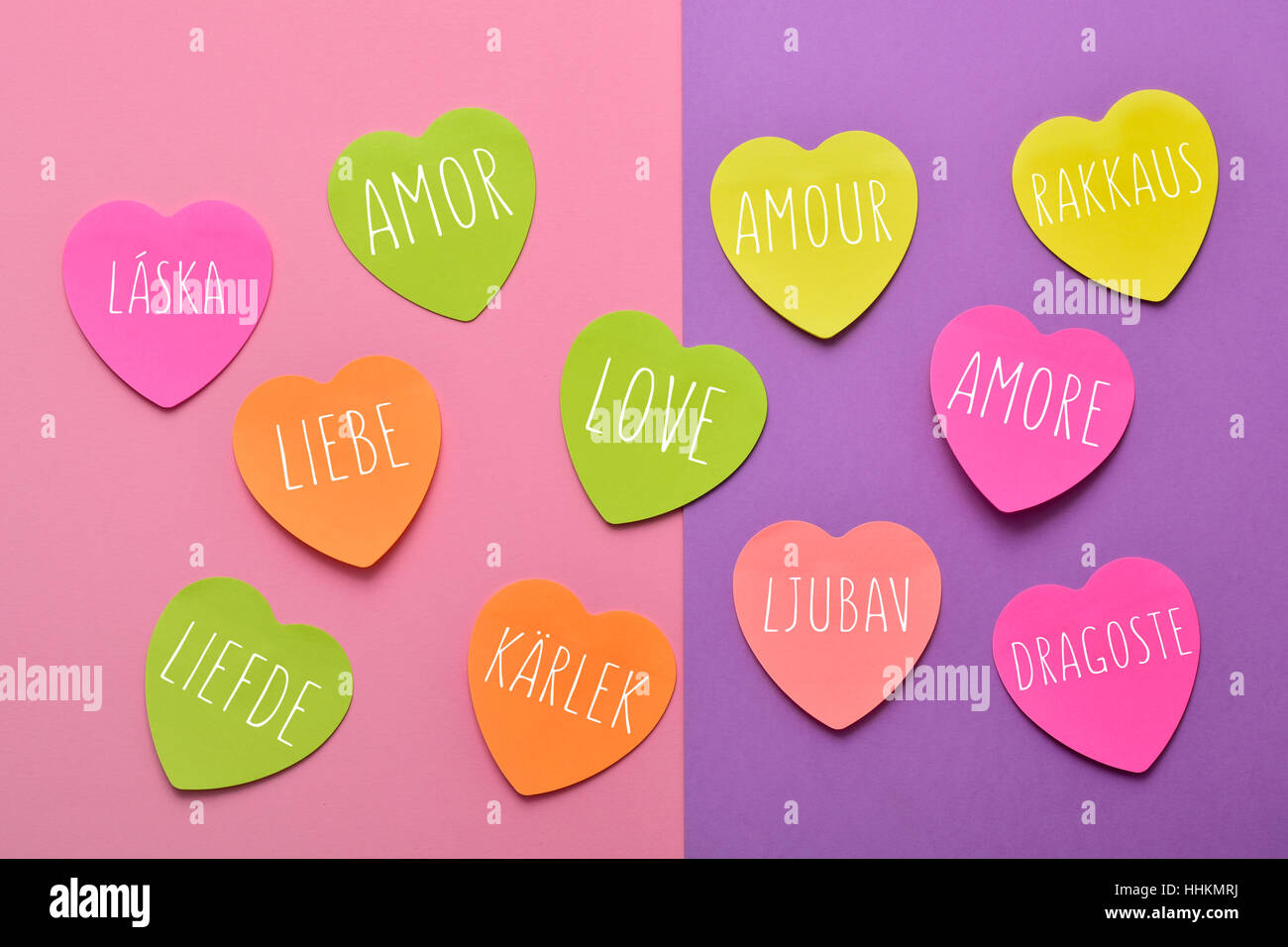 einige herzförmige Haftnotizen in verschiedenen Farben mit dem Wort Liebe geschrieben in verschiedenen Sprachen, wie Spanisch, Portugiesisch, Italienisch, Französisch, Po Stockfoto