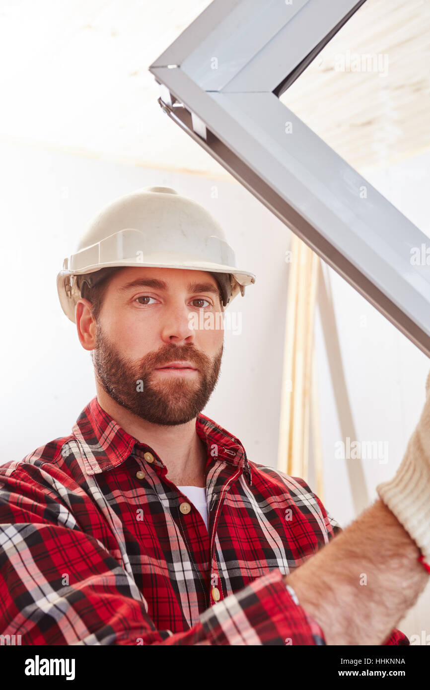 Bauarbeiter bauen neues Haus und passende Fenster Stockfoto