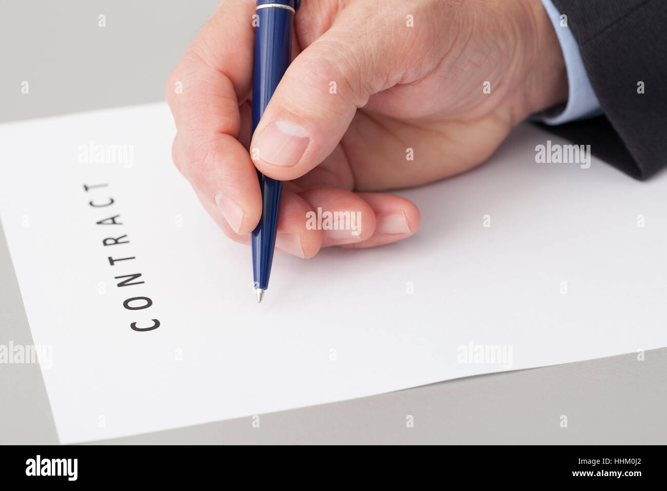 Hand der Geschäftsmann mit einem Stift schreiben einen Dokument-Vertrag auf einem Tisch im Büro. Stockfoto