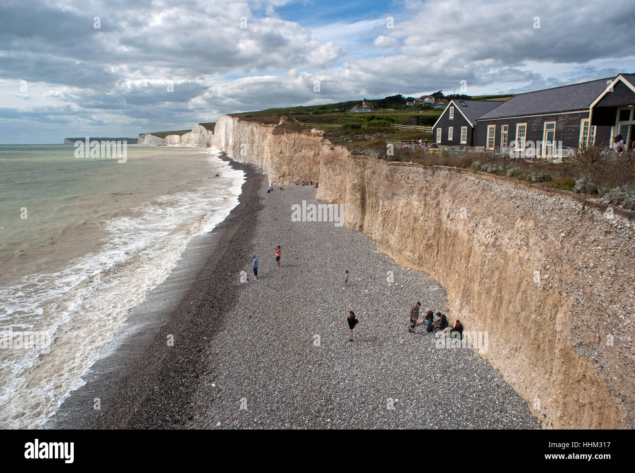 Familien am Meer unter Felsen Stockfoto