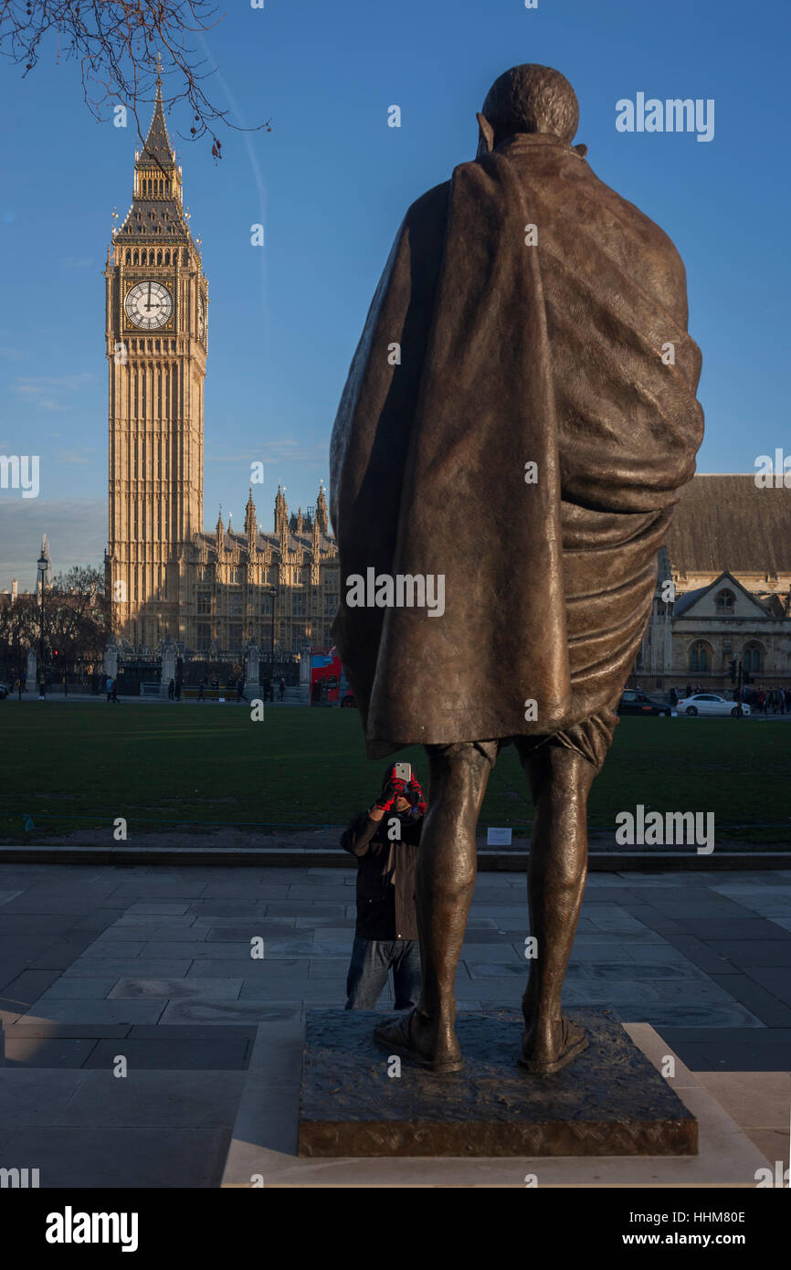 Das Denkmal für indische Führer Mahatma Gandhi mit den britischen Houses of Parliament im Hintergrund, am 18. Januar 2017, Parliament Square, London England. Mohandas Karamchand Gandhi war der überragende Führer der indischen Unabhängigkeitsbewegung im britisch beherrschten Indien. Stockfoto