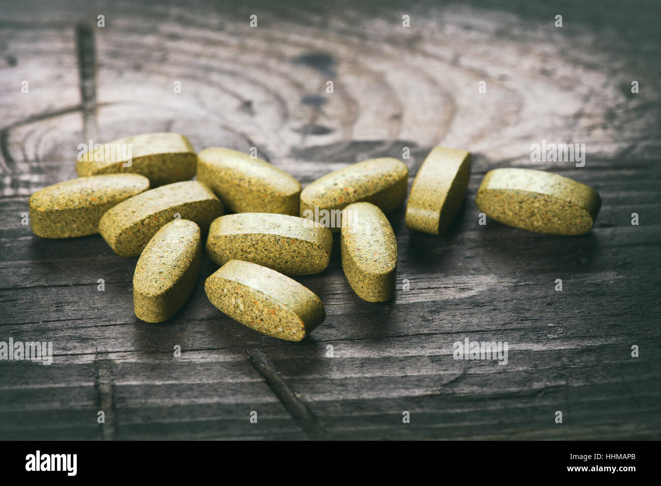 Grün Tabletten. Nahrungsergänzungsmittel auf einem Holztisch Stockfoto