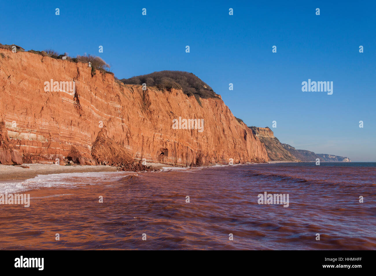 Sidmouth. Roten Sandsteinfelsen in Sidmouth, Devon, fallen in das Meer durch Küstenerosion. Der Felsen machen das Meer rot erscheinen. Stockfoto