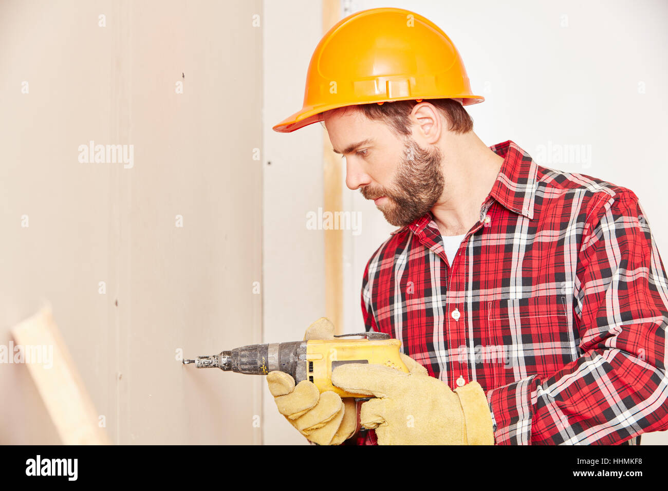 Facharbeiter Bohren während Renovierungsarbeiten am Gebäude Stockfoto