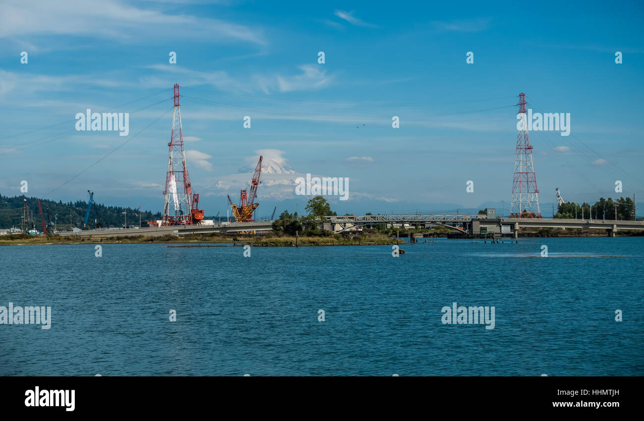 Mount Rainier erhebt sich hinter Stromleitungen am Port of Tacoma. Stockfoto