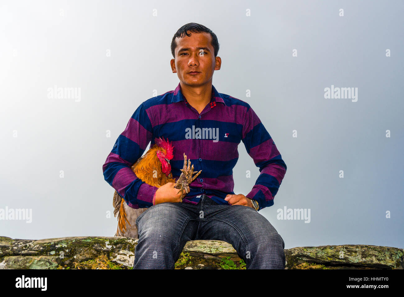 Lokale Mann sitzt mit einem Hahn, bald, geopfert zu werden, im Dorf Devi Mandir-Tempel, Darsain hinduistische Festival, Bandipur Stockfoto