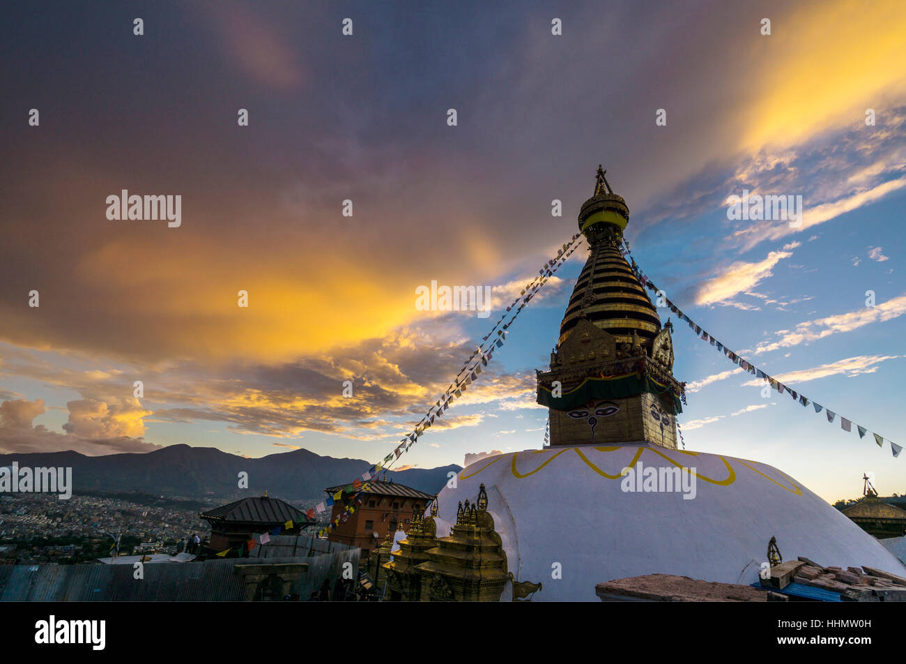 Stupa von Swayambhunath Tempel, Affe, dekoriert mit tibetischen Gebet Fahnen, orange Wolken, Kathmandu, Nepal Stockfoto