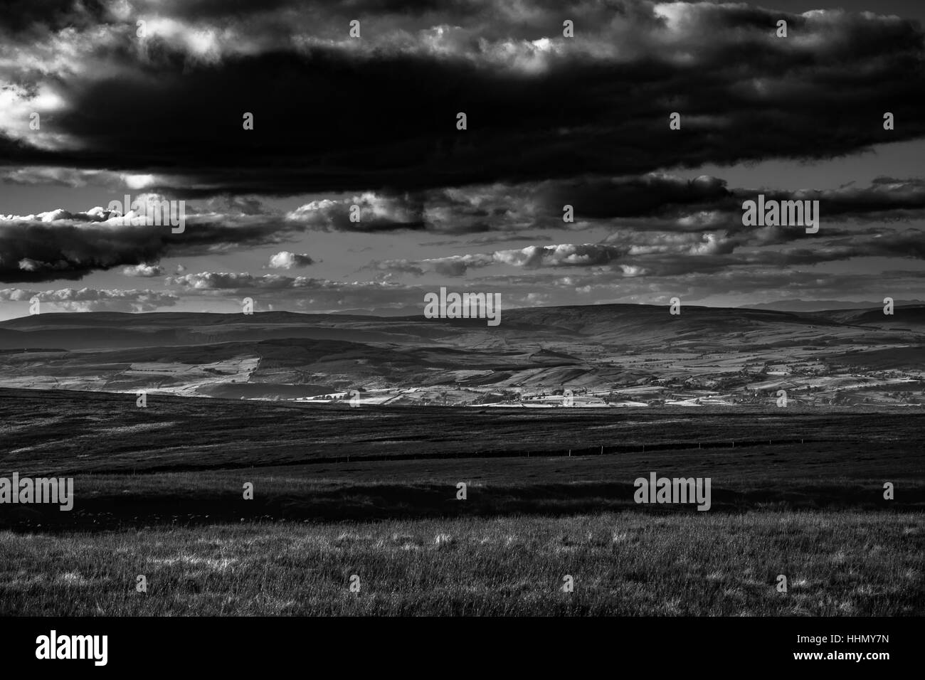 Ein Blick vom Pendle Hill. Wolken Schatten über Hügel. In Entfernung Seenplatte Bergen. Schwarz und weiß. Wald von Bowland. Lancashire. England, Stockfoto