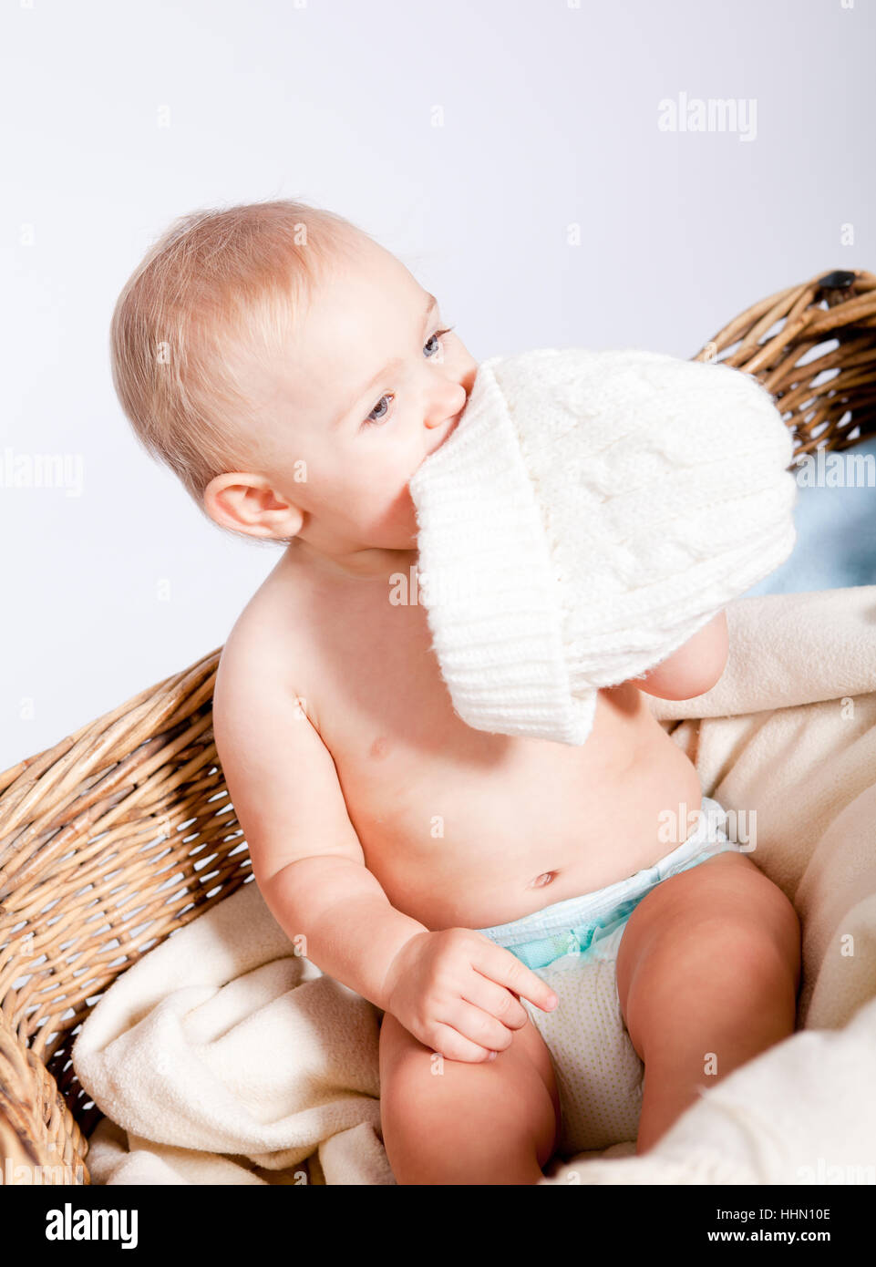 Kleines Baby Art erschienene in Einem Korb Mit Einer Windel Und Einer Mütze Vor Weißem hintergrund Stockfoto