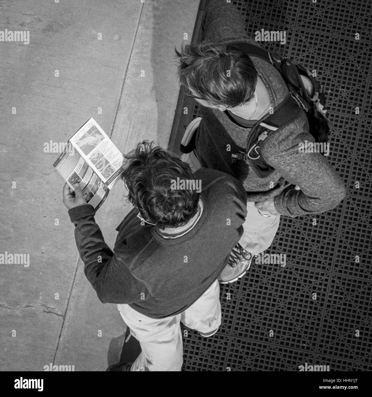 Zwei Männer, die Beratung eines Reiseleiters buchen und ordnen Sie am Kai in Vancouver Harbour, British Columbia, Kanada. Stockfoto