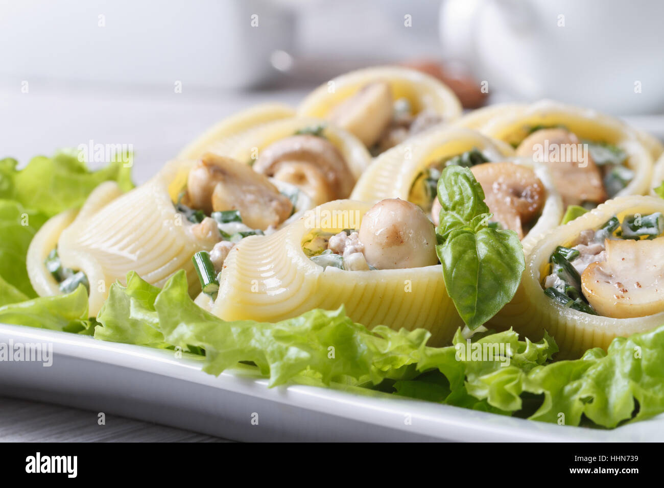 Lumakoni, die italienischer Pasta gefüllt mit Pilzen, Spinat und Käse Closeup auf einem weißen Teller. horizontale Stockfoto