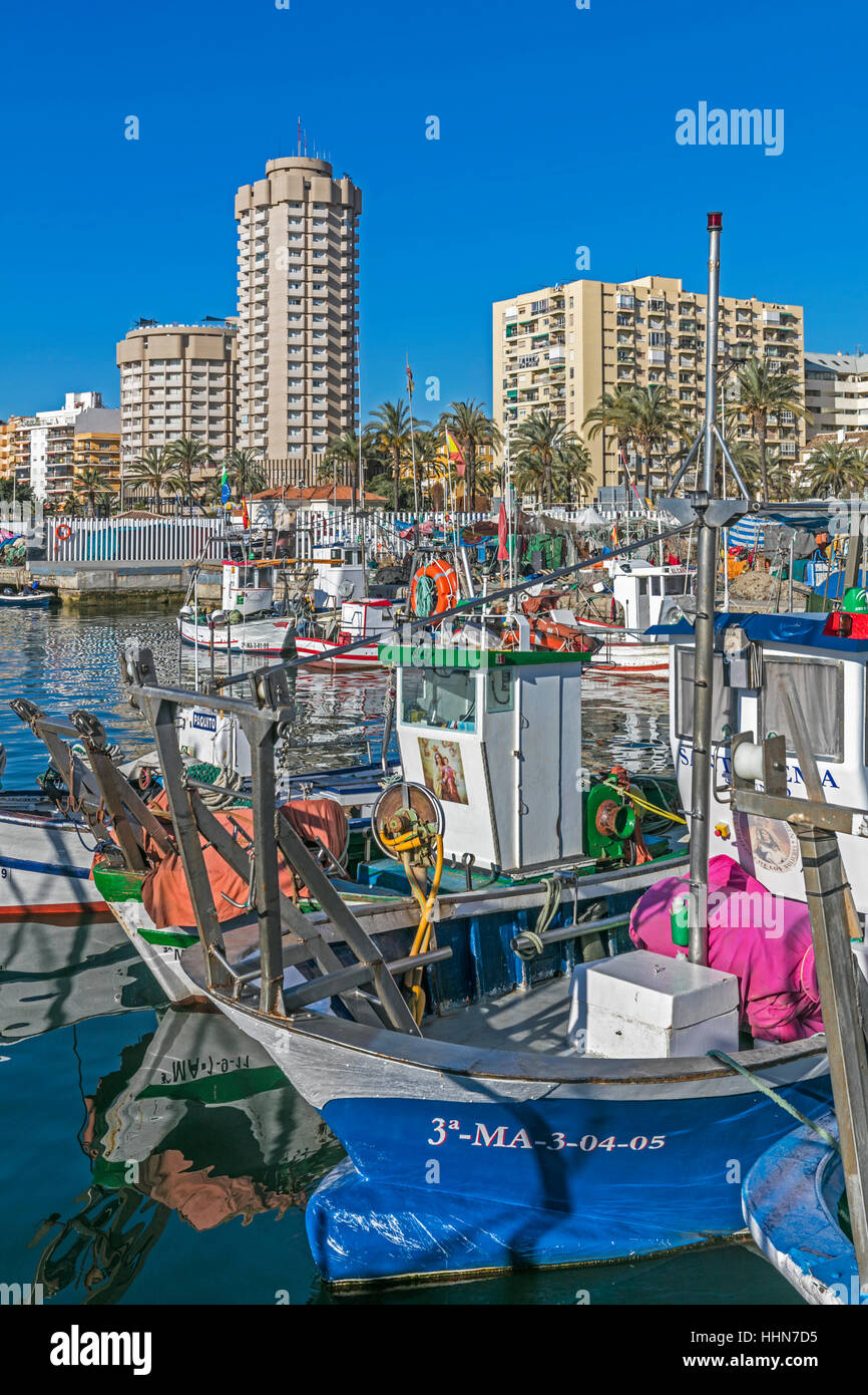 Fuengirola, Costa Del Sol, Provinz Malaga, Andalusien, Südspanien. Fischerboote im Hafen. Hotels und Wohnhäuser hinter. Stockfoto