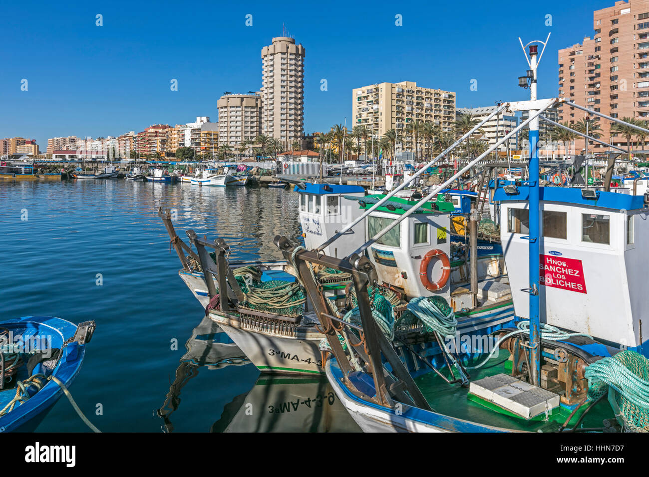Fuengirola, Costa Del Sol, Provinz Malaga, Andalusien, Südspanien. Fischerboote im Hafen. Hotels und Wohnhäuser hinter. Stockfoto