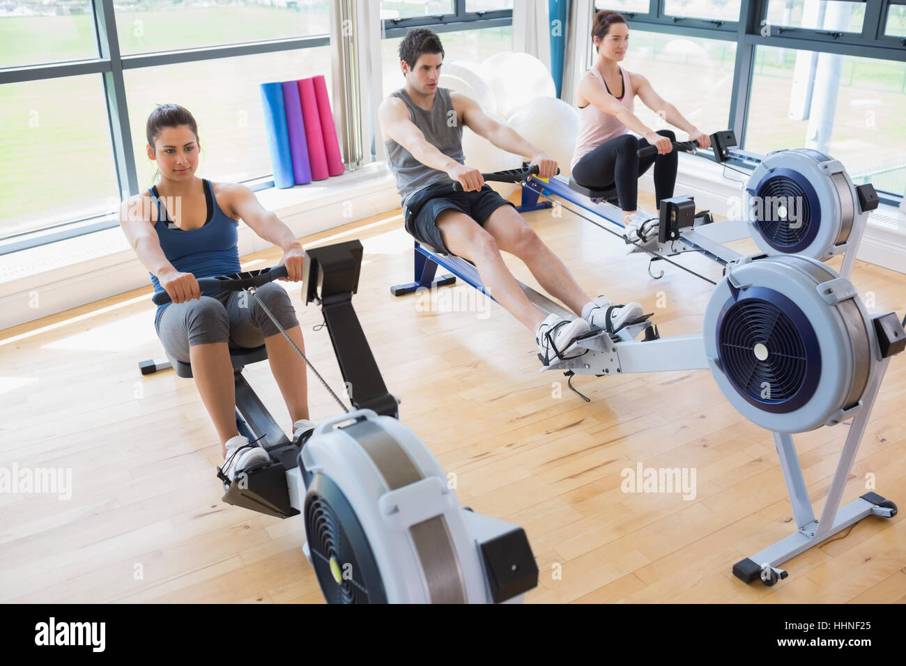 Personen mit Rudergeräte im Fitness-studio Stockfoto