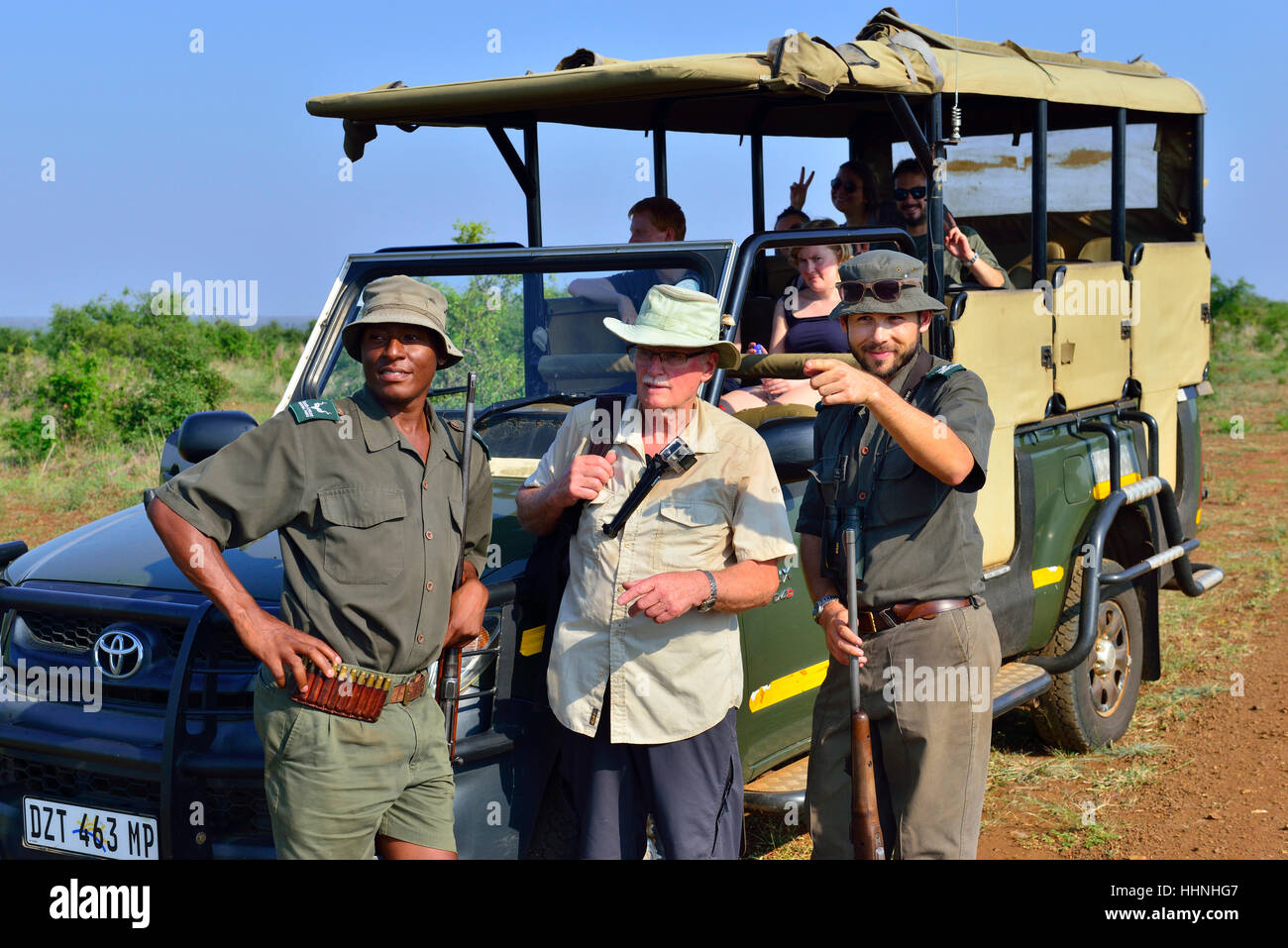 Party von Buschwanderern im Safari-Truck mit zwei Riflemen Kruger National Park Tracker zeigen die Richtung für Der Spaziergang Südafrika Stockfoto