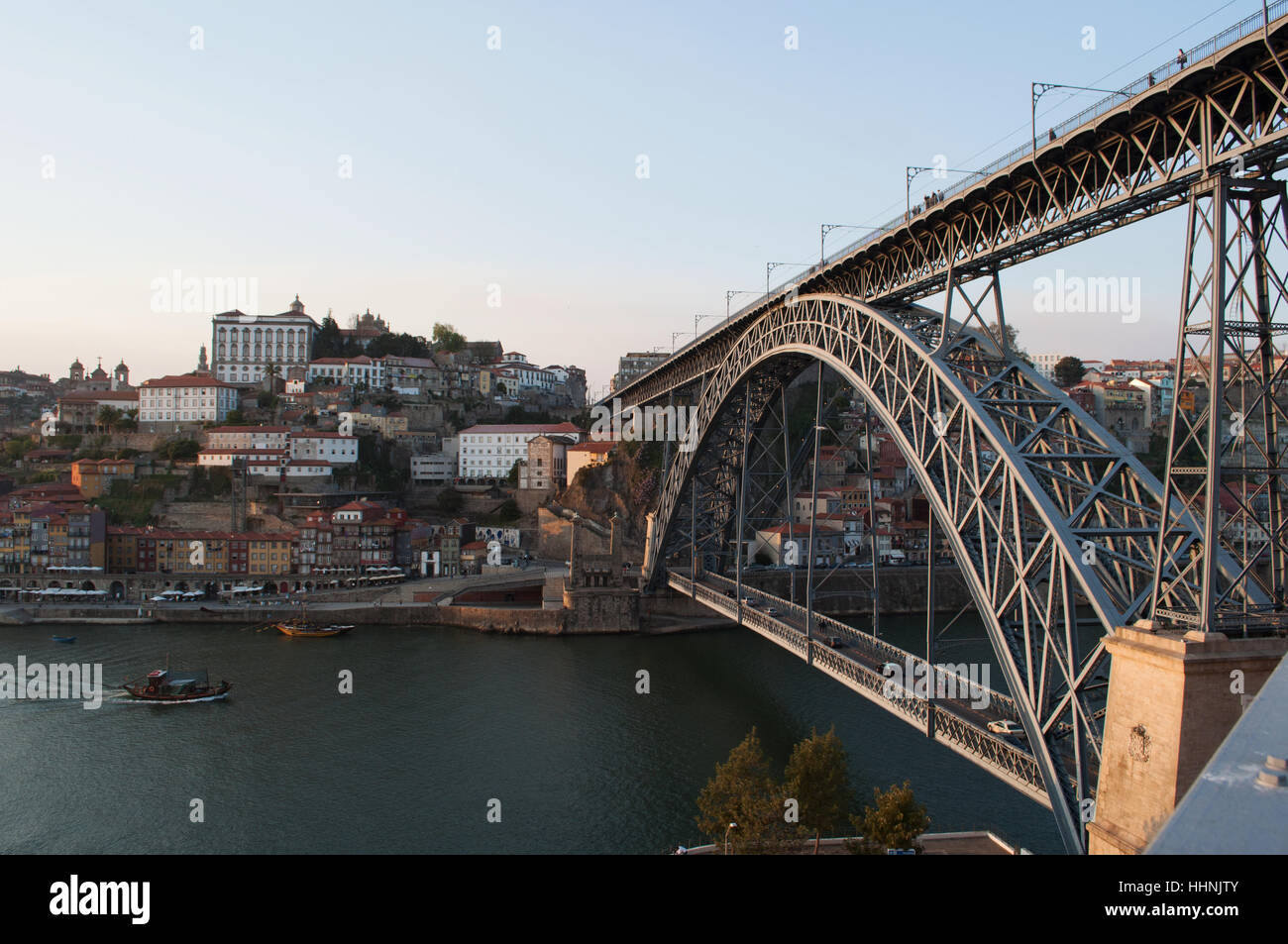 Portugal: Boote bei Sonnenuntergang und die Skyline von Porto mit Blick auf die Luiz I, die Doppel-gedeckten Metall Bogenbrücke über den Fluss Douro Stockfoto