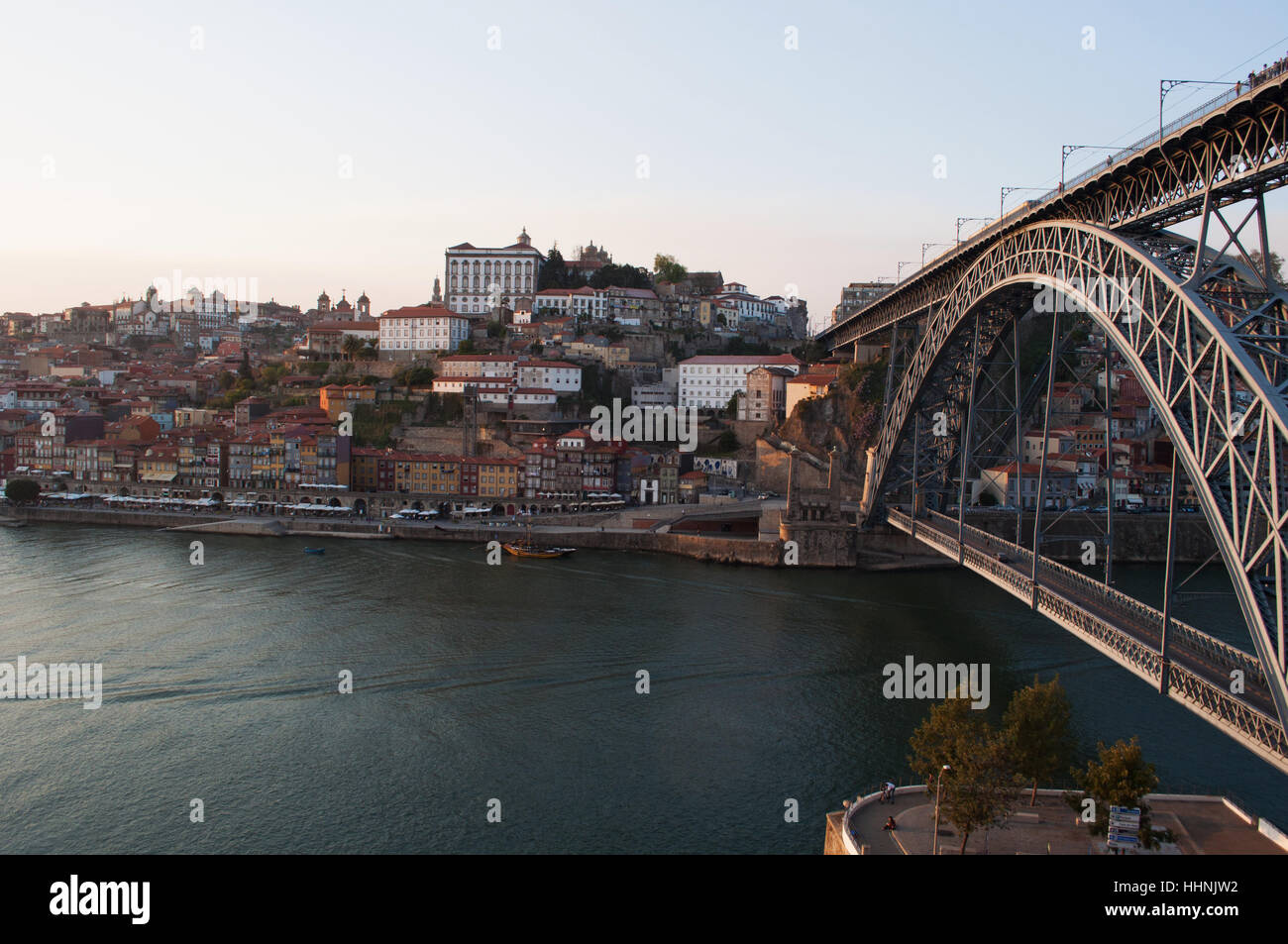 Portugal: Boote bei Sonnenuntergang und die Skyline von Porto mit Blick auf die Luiz I, die Doppel-gedeckten Metall Bogenbrücke über den Fluss Douro Stockfoto