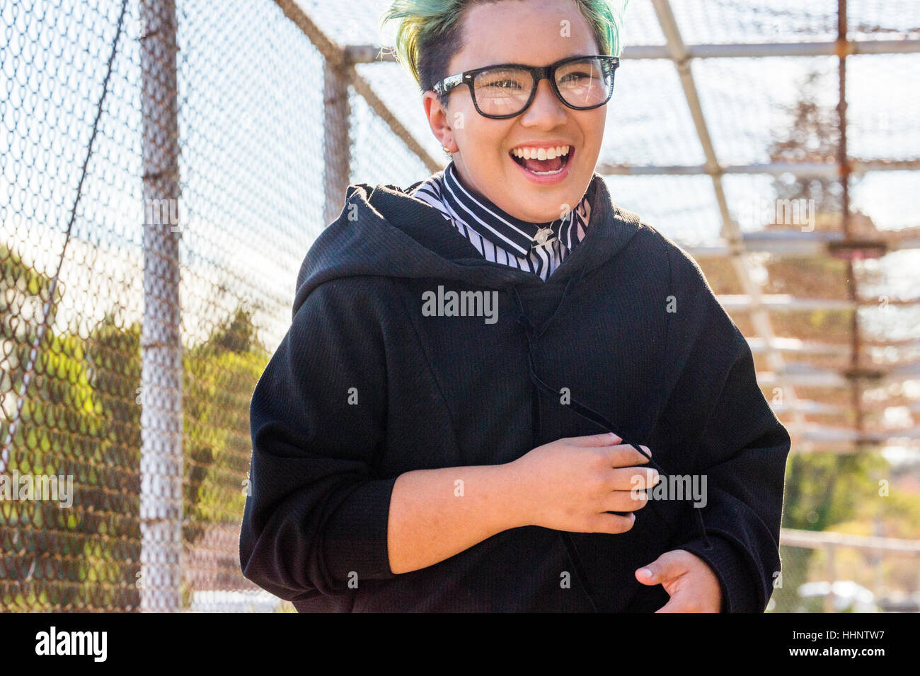 Androgyne asiatische Frau lachend auf Steg Stockfoto