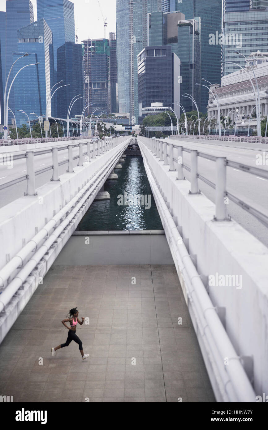 Gemischte Rennen Frau läuft unter städtischen Brücke Stockfoto