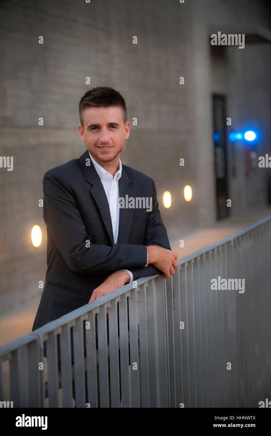 Porträt von lächelnden Geschäftsmann stützte sich auf Geländer Stockfoto