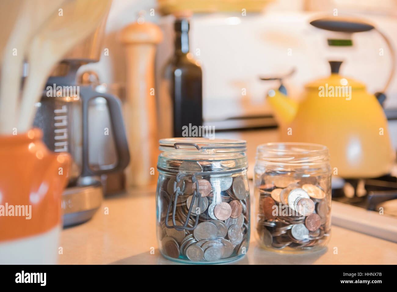 Gläser von Münzen auf Küchentisch Stockfoto