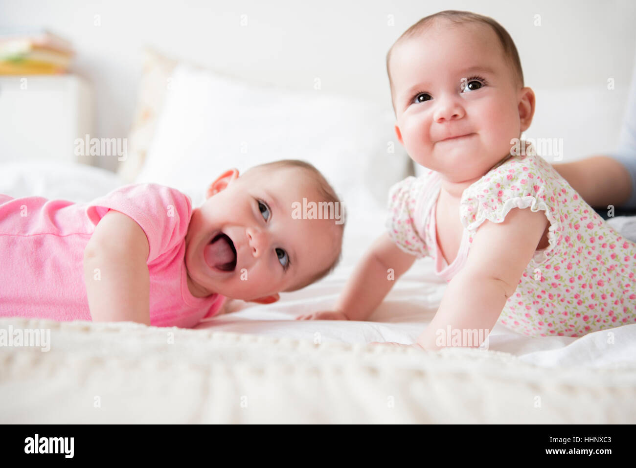 Glücklich kaukasischen Baby Zwillingsmädchen auf Bett Stockfoto