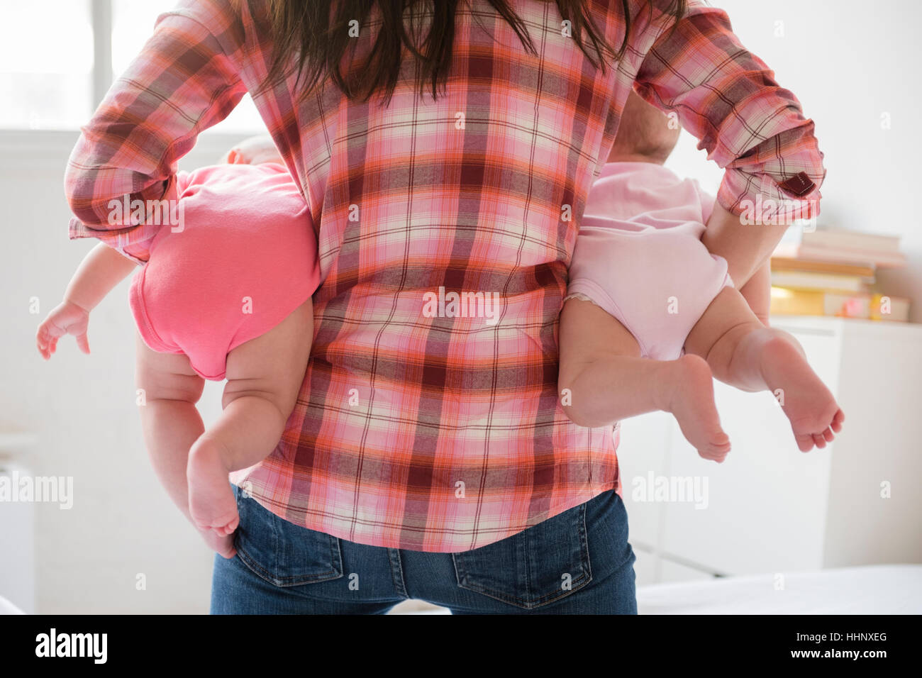 Kaukasische Mutter hält Baby Zwillingstöchter Stockfoto